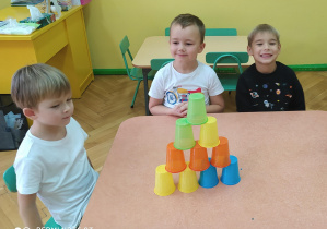 Chłopcy podczas układania kolorowych kubków wg podanego wzoru